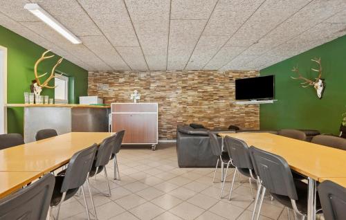 a conference room with tables and chairs and a flat screen tv at Holiday Home Stikkelsbærvej Tarm Iv in Hemmet