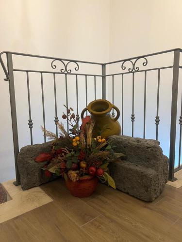 a vase and a basket of flowers next to a bed at Austinu e Bingedda's Home in Ardara