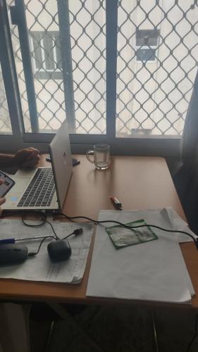 a desk with a laptop computer and mouse on it at Muscat Galaxy Hostel in Muscat