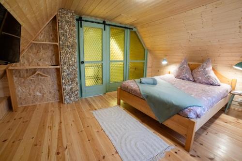 a bedroom with a bed in a wooden cabin at Házikó Balatonalmádi in Balatonalmádi