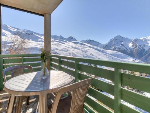 a table and chairs on a balcony with snow covered mountains at Appartement 3 Pièces 6 Personnes MAE-9803 in Germ