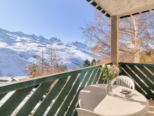 a table and chairs on a balcony with snow covered mountains at Appartement 3 Pièces 6 Personnes MAE-9803 in Germ