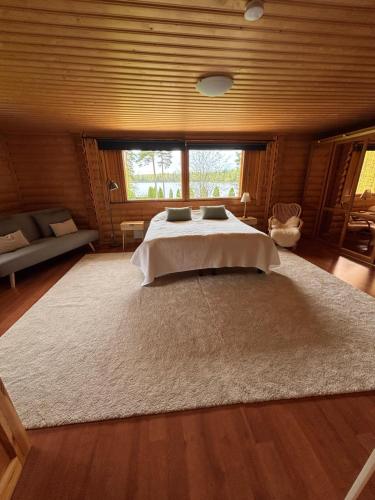 a bedroom with a bed with a large rug at Villa Jalaja in Mäntyharju