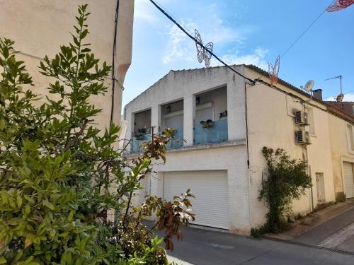 a building with two garage doors and a balcony at Maison cosy à Pérols - proche plage & Parc Expo Arena - clim, garage in Pérols