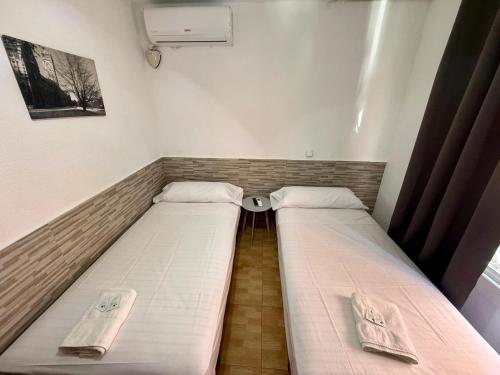 two beds in a small room with at PENSIÓN ROSA in Benidorm