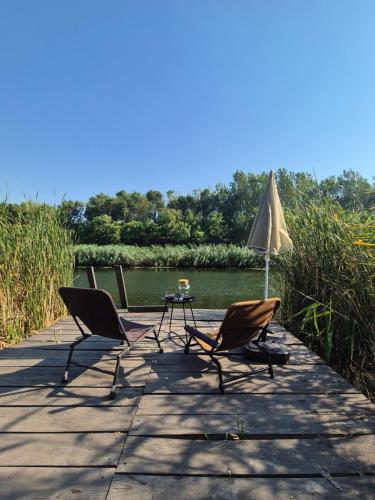 two chairs and a table and an umbrella on a dock at Avalon Mali Stapar 