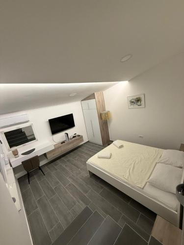a bedroom with a bed and a desk and a television at Villa Mirna in Mostar