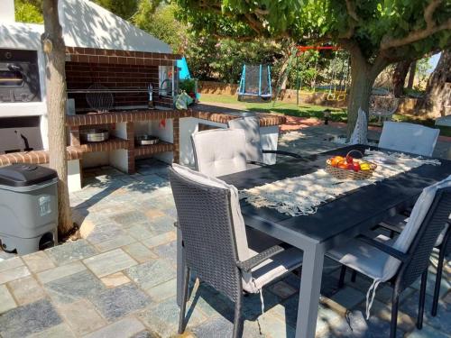 a table and chairs on a patio with a grill at Villa Polyxeni Lavender 150m from the sea in Politiká