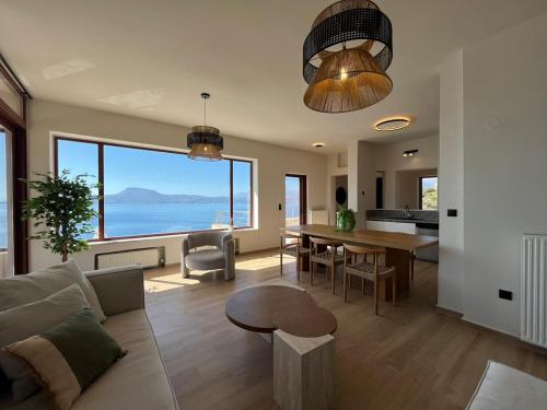 a living room with a couch and a table with a view at SeaWave Villas, By Hellocrete in Chania Town