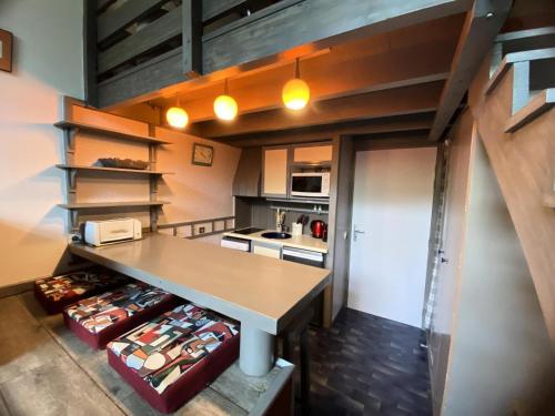 - une cuisine avec une table au milieu d'une pièce dans l'établissement Résidence Petaru - Spacieux duplex pour 4 personnes situé à Méribel centre proche des commerces MAE-2143, à Les Allues
