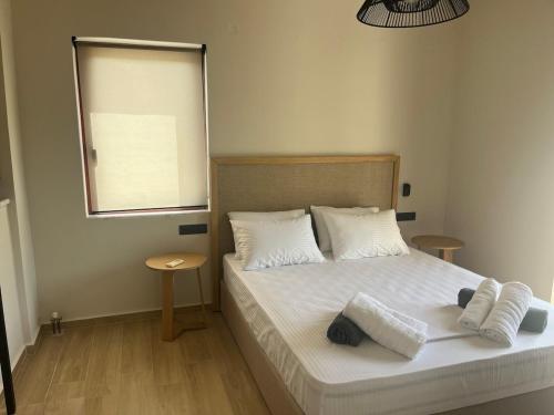a bedroom with a bed with white sheets and pillows at SeaWave Villas, By Hellocrete in Chania Town