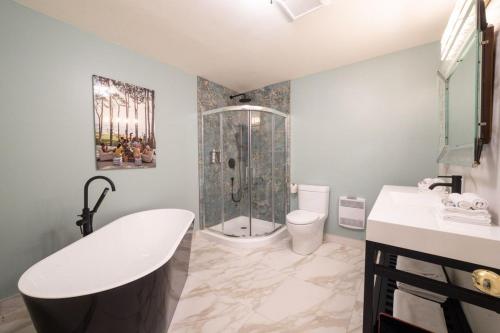 a bathroom with a tub and a shower and a toilet at Motel Chelsea in Chelsea