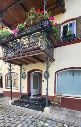 a building with a balcony with flowers on it at Ferienwohnungen Heinrichsberger in Bad Aibling