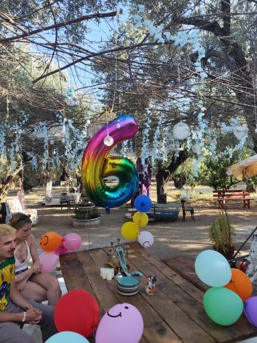 a group of children sitting on a table with balloons at Asmanis Rooms in Tarti