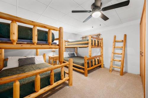 a room with two bunk beds and a ceiling fan at Scenic Spider Lake Beach Resort Pontoon Rentals in Traverse City