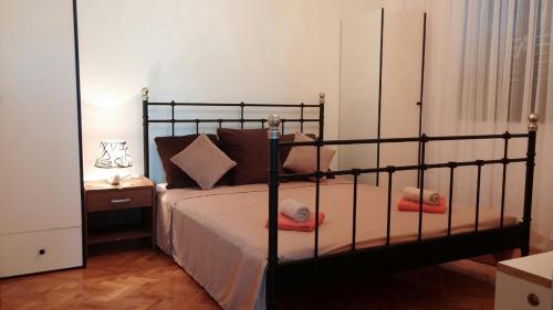 a bedroom with a black bed with pillows on it at Agrotourism Galic Krka in Drinovci