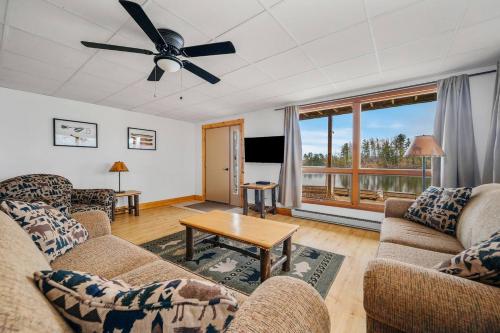 a living room with two couches and a table at Scenic Spider Lake Beach Resort Pontoon Rentals in Traverse City