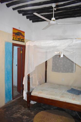 a bed with a canopy in a room at Budget self-contained room on the GROUND FLOOR at JamboHouse Lamu in Lamu
