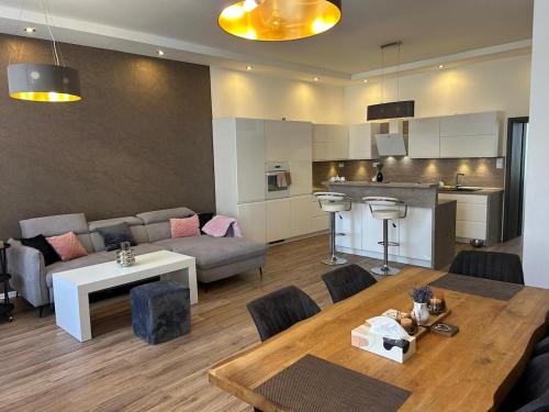 un soggiorno con un divano, un tavolo e una cucina di Luxusní apartmán v centru Jihlavy a Jihlava