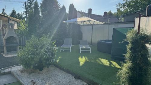 a small yard with two chairs and an umbrella at Villa Negra 1 in Balatonfenyves