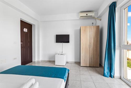 ein Schlafzimmer mit einem Bett, einem Fernseher und einem Fenster in der Unterkunft Vila Bella 2M in Costinești