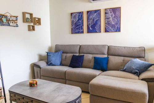 a living room with a brown couch and blue pillows at Cozy Condo with Panoramic Hillside Views from Rooftop Terrace and Short Walk to Beach in Coco