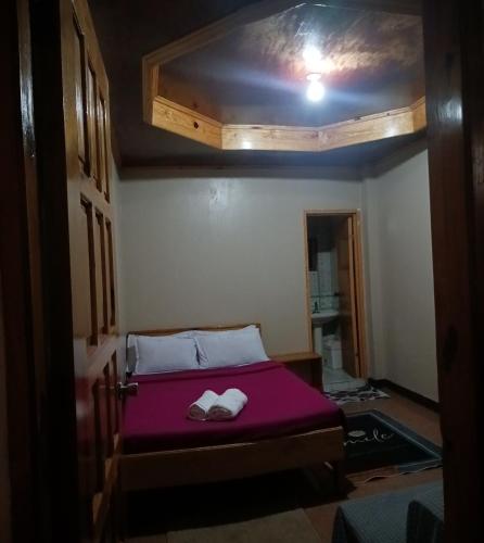 a bedroom with a bed with two towels on it at MOTHER MARRY INN in Sagada