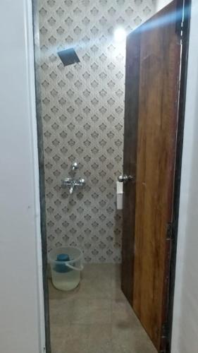 a bathroom with a toilet and a wooden door at Spanish villa , chinchoti in Bapane