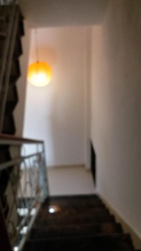a hallway with a staircase with a light on the wall at Spanish villa , chinchoti in Bapane