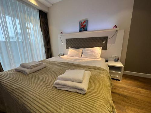 a bedroom with a large bed with towels on it at alliance pearl Batumi in Batumi