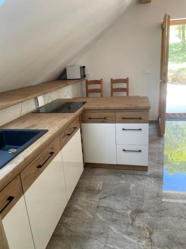 a kitchen with white cabinets and a sink at Zerko Holiday Apartment Janko with a private outdoor jacuzzi for FREE in Mirna