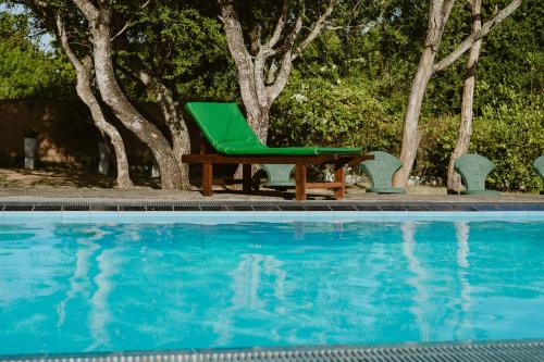 a green chair sitting next to a swimming pool at Yala Green Eco Lodge in Kirinda