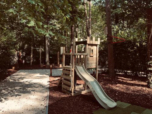 a playground with a slide in a park at Five Trees Forest Home in Lanaken