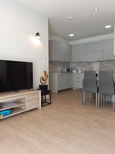 a living room with a television and a table and chairs at Sandstone Residence St Julian's - 2 bedrooms in Tal-Franċiż