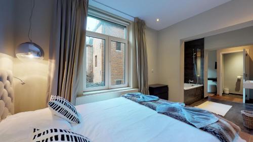 a bedroom with a large bed and a window at Villa Sablon in Brussels