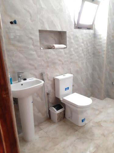 a bathroom with a white toilet and a sink at Beach Front Villa in Souira Guedima