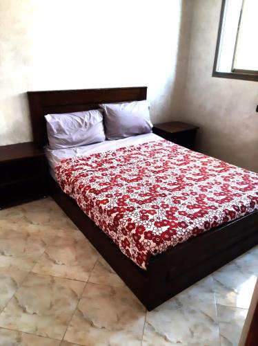 a bedroom with a bed with a red blanket at Beach Front Villa in Souira Guedima
