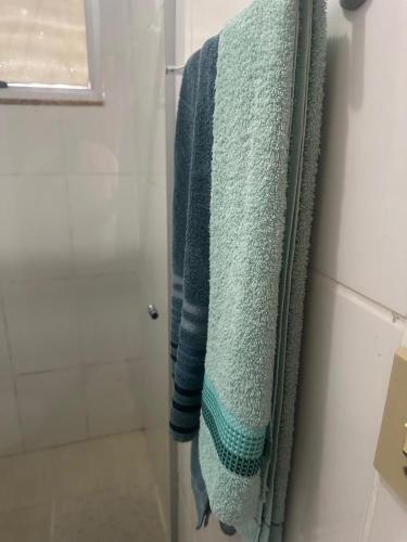 a bathroom with a blue towel hanging in a shower at Hospedagem Aconchego in Lagoa Santa