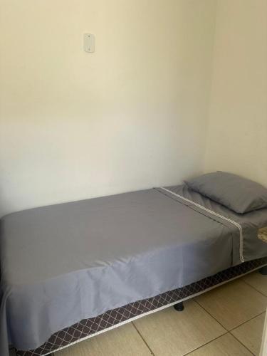 a bed sitting in a room next to a wall at Hospedagem Aconchego in Lagoa Santa