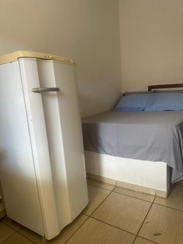 a small bedroom with a bed and a dresser at Hospedagem Aconchego in Lagoa Santa