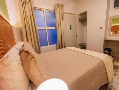 a bedroom with a bed in front of a window at Casa Mayahuel in Oaxaca City