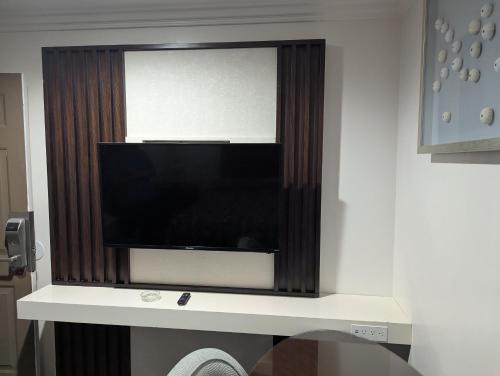 a flat screen tv sitting on a wall at Airport Motel - Inglewood in Inglewood