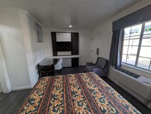 a hotel room with a bed and a desk at Airport Motel - Inglewood in Inglewood
