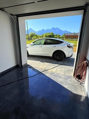a white car parked inside of a garage at Villa Lilien Residence Tatry in Veľká Lomnica