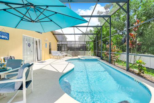 a swimming pool with an umbrella in a backyard at South Facing Pool with Spa and a Game Room in Prime Location Near Disney in Kissimmee