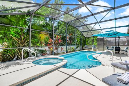 a swimming pool in a glass house with a swimming poolvisor at South Facing Pool with Spa and a Game Room in Prime Location Near Disney in Kissimmee
