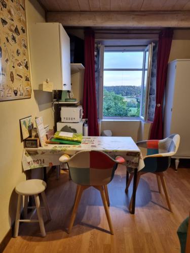 une cuisine avec une table et des chaises ainsi qu'une fenêtre dans l'établissement Bienvenue chez Bernard, à Saint-Paulien