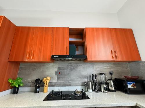 a kitchen with wooden cabinets and a stove top at Spacious 3rd Floor 1Bedroom Apartment in Bunga in Muyenga 