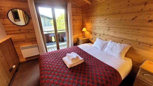 une chambre avec un lit dans une cabane en rondins dans l'établissement Résidence Hermitage Ii - Appartement proche centre et pistes MAE-2381, aux Gets