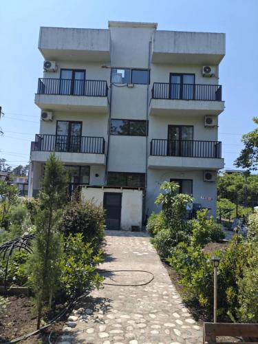a tall white building with balconies on it at ilios in K'obulet'i